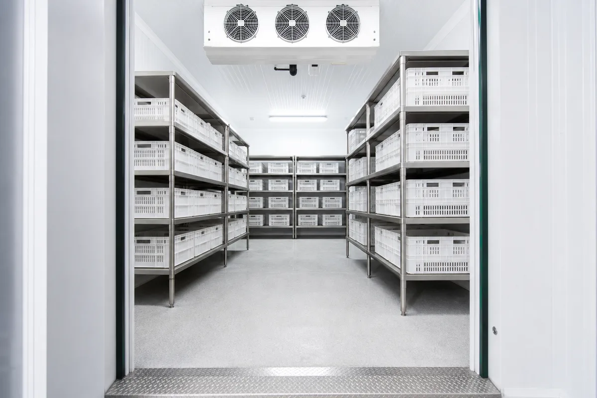 Intérieur d’une chambre froide positive en panneaux sandwich avec rayonnages inox et évaporateur plafonnier